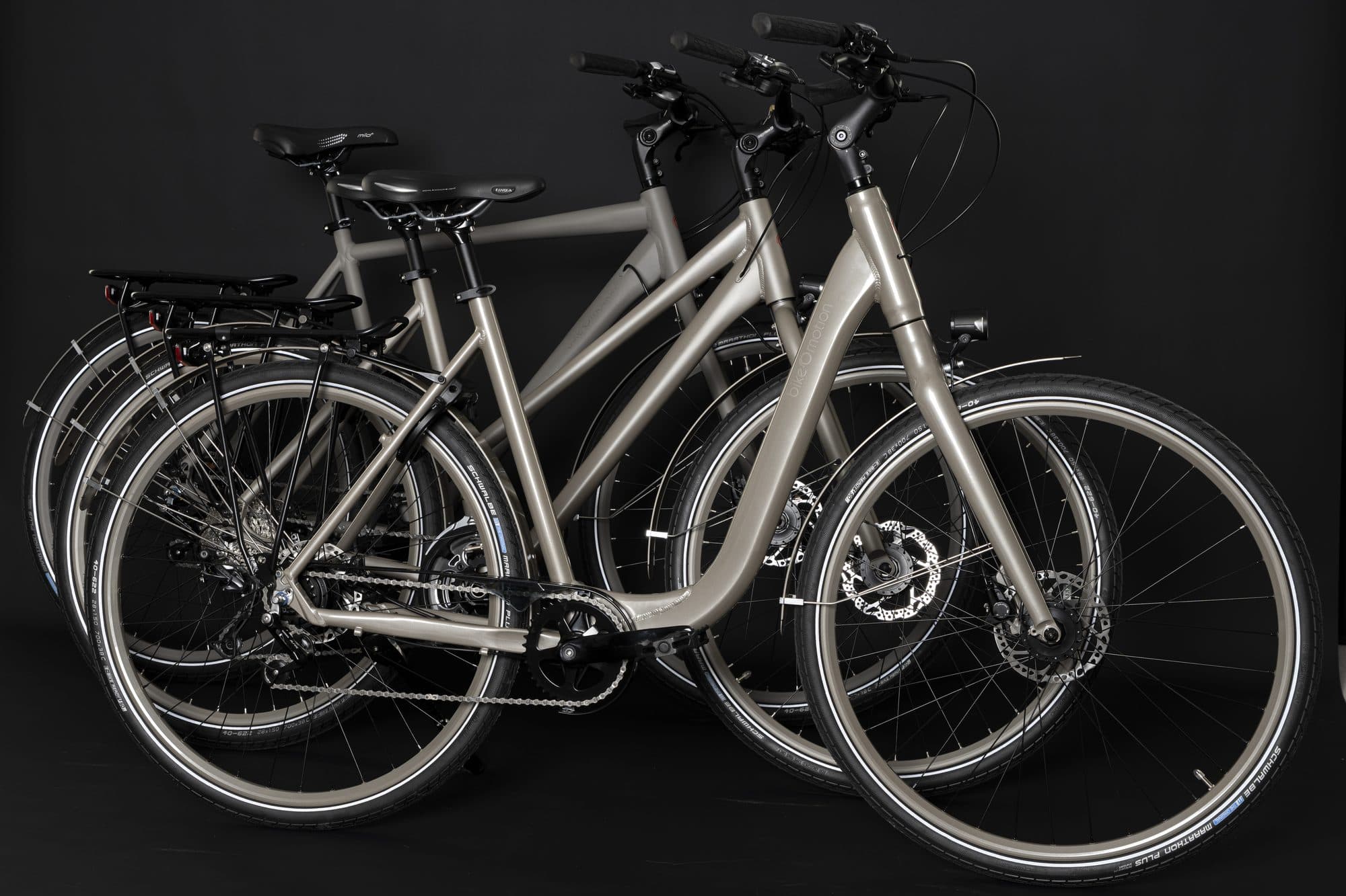 Drei bikeOmotion-Räder in Kupfer, Silber und Schwarz vor dunklem Hintergrund