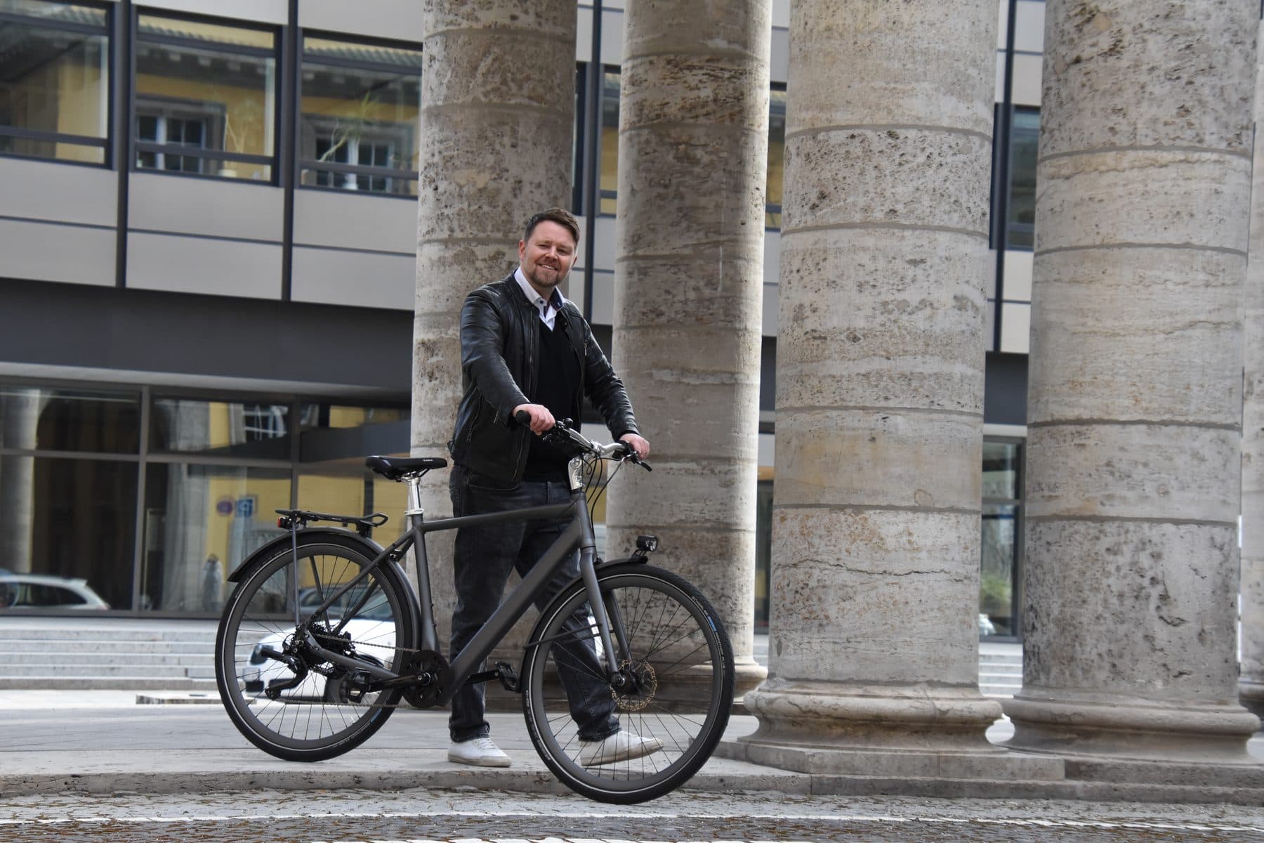 Mann mit bikeOmotion-Rad vor den Säulen am Königsplatz